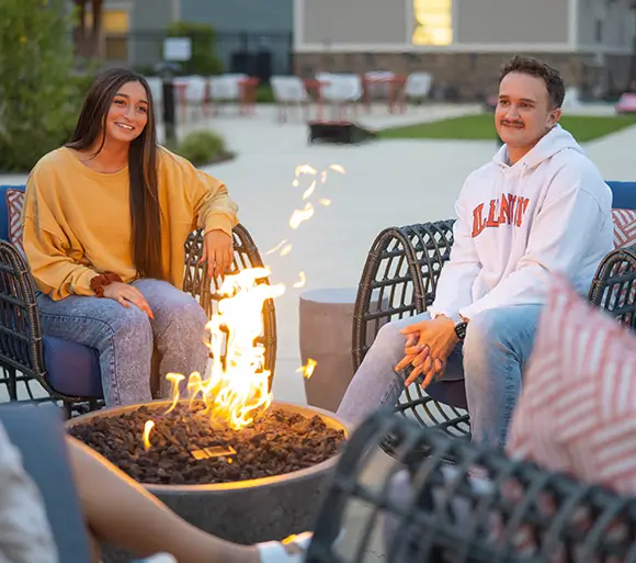 group of young adults by a fire pit